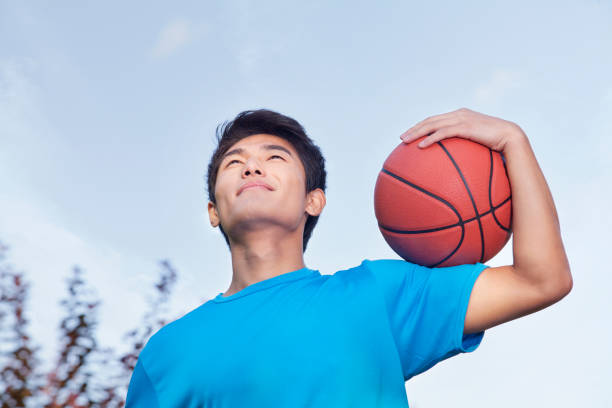 istock Chinese man holding basketball 1082651922