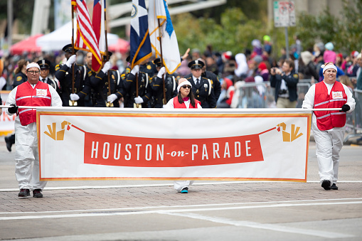 Houston, Texas, USA - November 22, 2018 The H-E-B Thanksgiving Day Parade, Men and woman holding a banner that says Houston on Parade