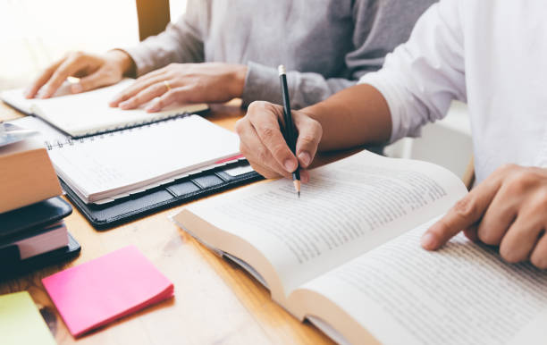 istock Teenage student works on homework in his room and writing in notebook. 1082666066