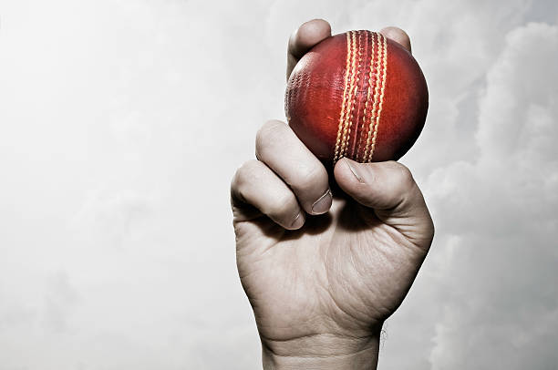 balle de cricket dans la main - cricket bowler photos et images de collection