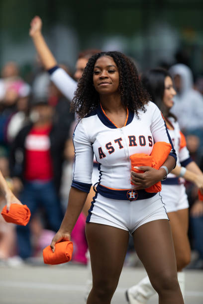 H-E-B Thanksgiving Day Parade Houston, Texas, USA - November 22, 2018 The H-E-B Thanksgiving Day Parade, Cheerleaders from the Astros Baseball team giving spectators free shirts houston astros stock pictures, royalty-free photos & images