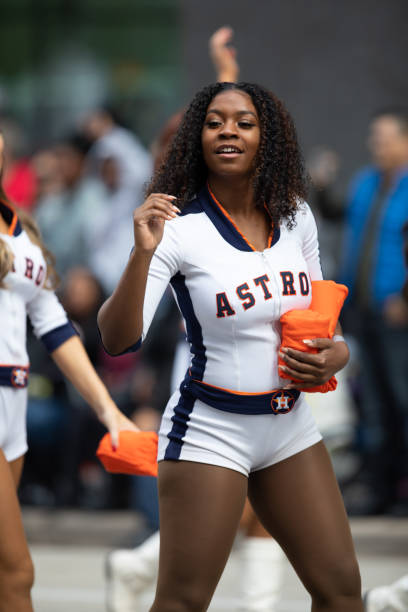 H-E-B Thanksgiving Day Parade Houston, Texas, USA - November 22, 2018 The H-E-B Thanksgiving Day Parade, Cheerleaders from the Astros Baseball team giving spectators free shirts houston astros stock pictures, royalty-free photos & images