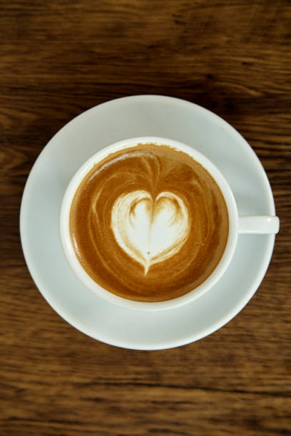istock A cup of coffee with heart pattern in a white cup on wooden background 1082676920