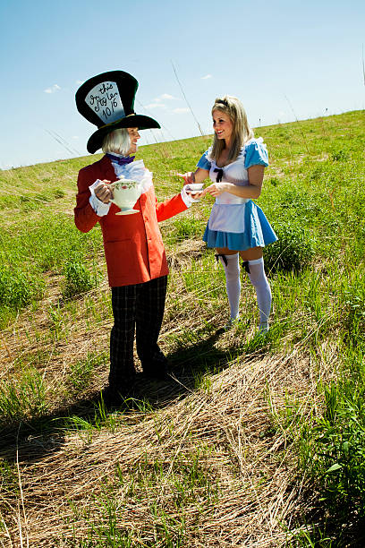 безумного шляпника и alice в wonderland - bizarre hatter alice in wonderland tea party стоковые фото и изображения