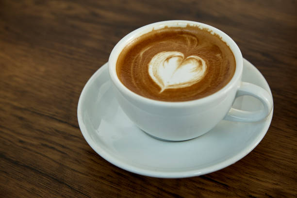 istock A cup of coffee with heart pattern in a white cup on wooden background 1082676996