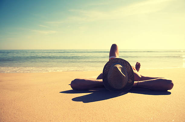 hombre relajante viaje en la playa tranquila usando sombrero vintage - lying on back fotos fotografías e imágenes de stock