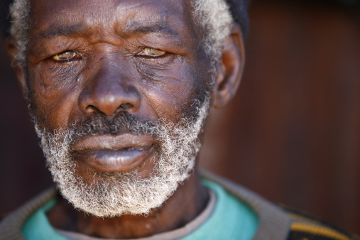 Close up portrait of an aged, grey haired African man, from rural South Africa. Photo has a shallow depth of field.