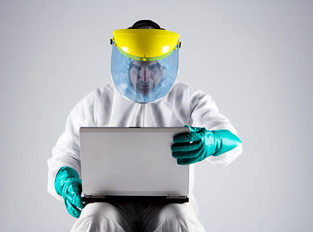laptop-virus schutz - radiation protection suit toxic waste protective suit cleaning stock-fotos und bilder