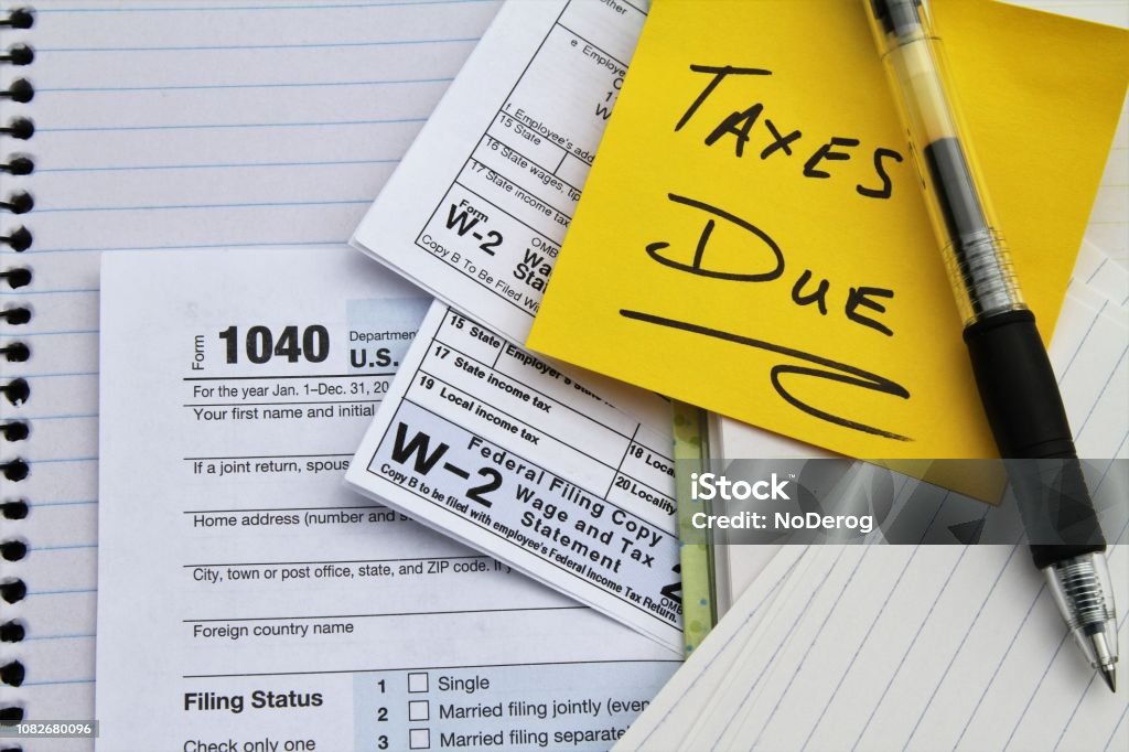 Tax return forms and wage statements with note Taxes Due. Tax return forms and wage statements with a note saying Taxes Due. An IRS tax return form 1040 and two W-2 Wage and Tax Statement forms indicating wages were earned from two employers. Tax Form Stock Photo