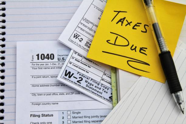 Tax return forms and wage statements with note Taxes Due. stock photo
