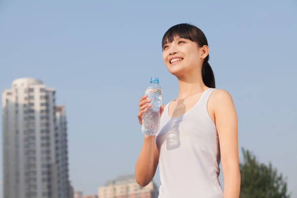 istock Chinese woman drinking water after exercise 1082680644