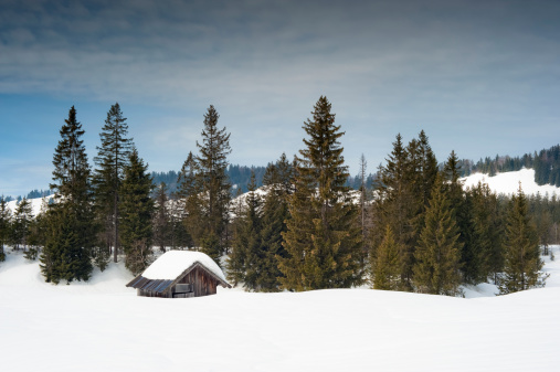 Beautiful winter landscape with small cabin in the foreground. 