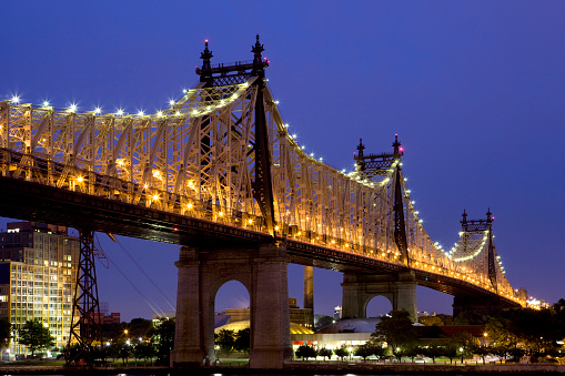 Also known as the 59th Street Bridge, illuminated at dusk with a view of Roosevelt Island, New York City.