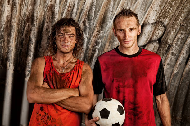 istock Two Young Men Covered in Mud Posing with Soccer Ball 108268244