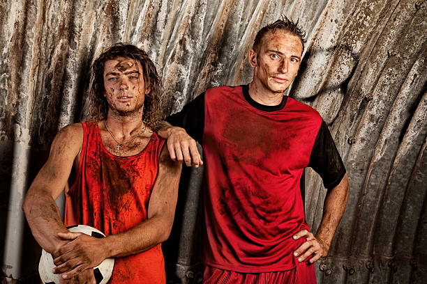 istock Two Young Men Covered in Mud Posing with Soccer Ball 108268279