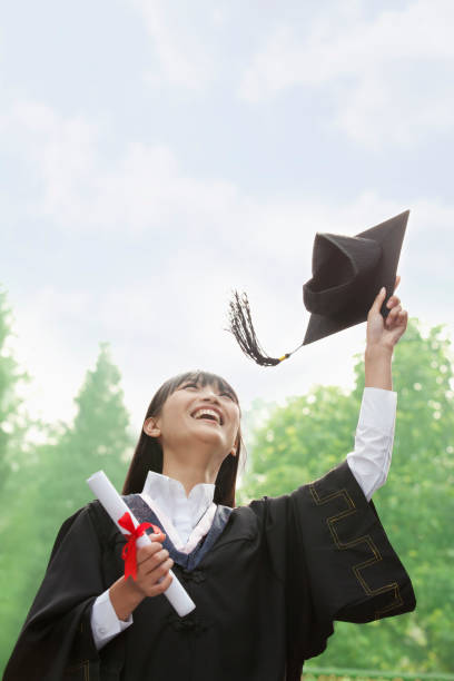 中国の女性彼女の鏝板に投げて、ディプロマを保持 - cheering arms raised women university ストックフォトと画像