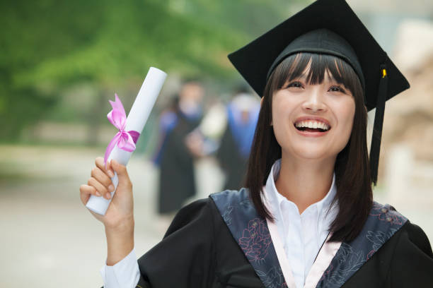 istock Cheering Chinese student in graduation cap and gown holding diploma 1082683312