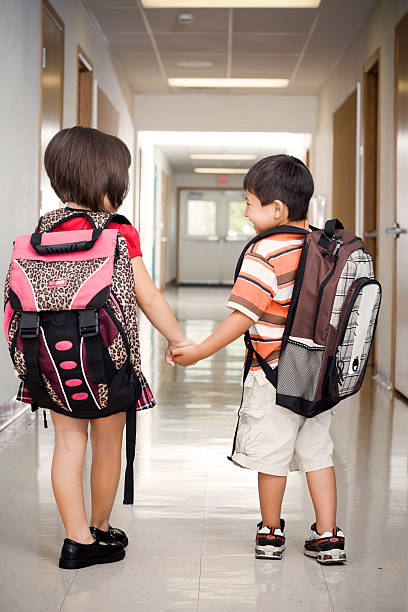 istock Adorable Two Kids Holding Hands in Elementary School Hallway 108268337