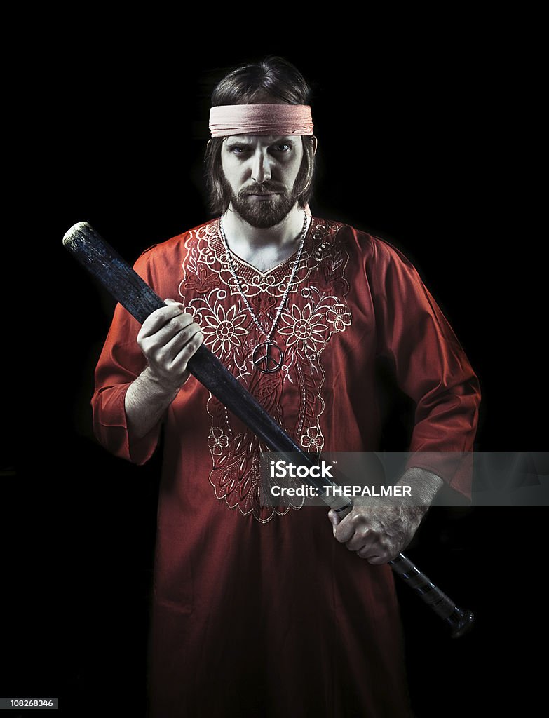 no more mr. nice guru young guy with dress as a guru holding a vintage baseball bat and staring a t camera with a mean look. Guru Stock Photo