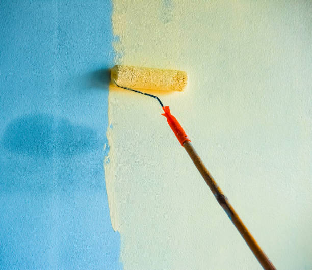istock painted wall background / hand painting wall with paint roller on building construction 1082683496