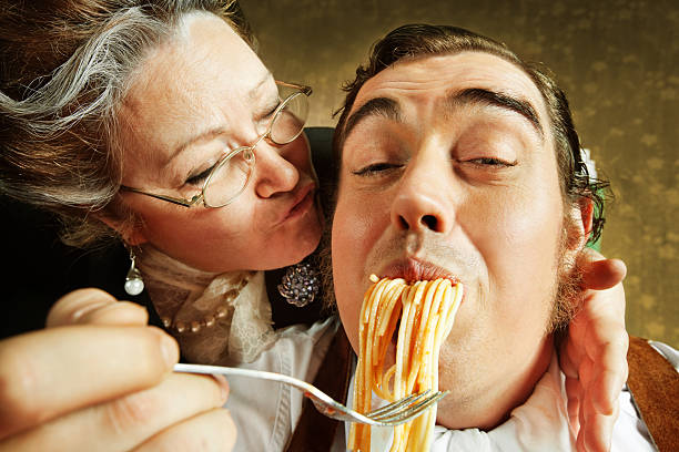 adulto mãe filho alimentação por excesso de massa - eating senior adult color image spaghetti imagens e fotografias de stock