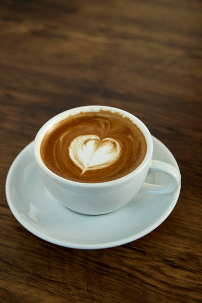 istock A cup of coffee with heart pattern in a white cup on wooden background 1082685106