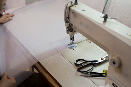 Close up woman working with sewing modern machine