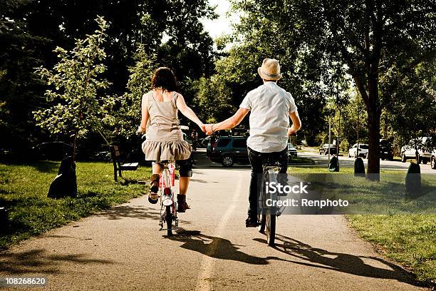 Пара Держа Руки И Riding Bikes — стоковые фотографии и другие картинки 20-29 лет - 20-29 лет, Близость, В полный рост