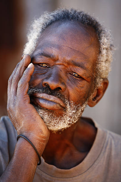 Portrait of Senior African Man Resting Chin in Hand stock photo