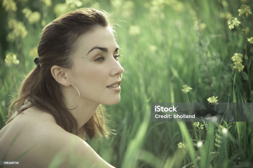 Young Woman Sitting in Green Field Meadow  Summer Stock Photo