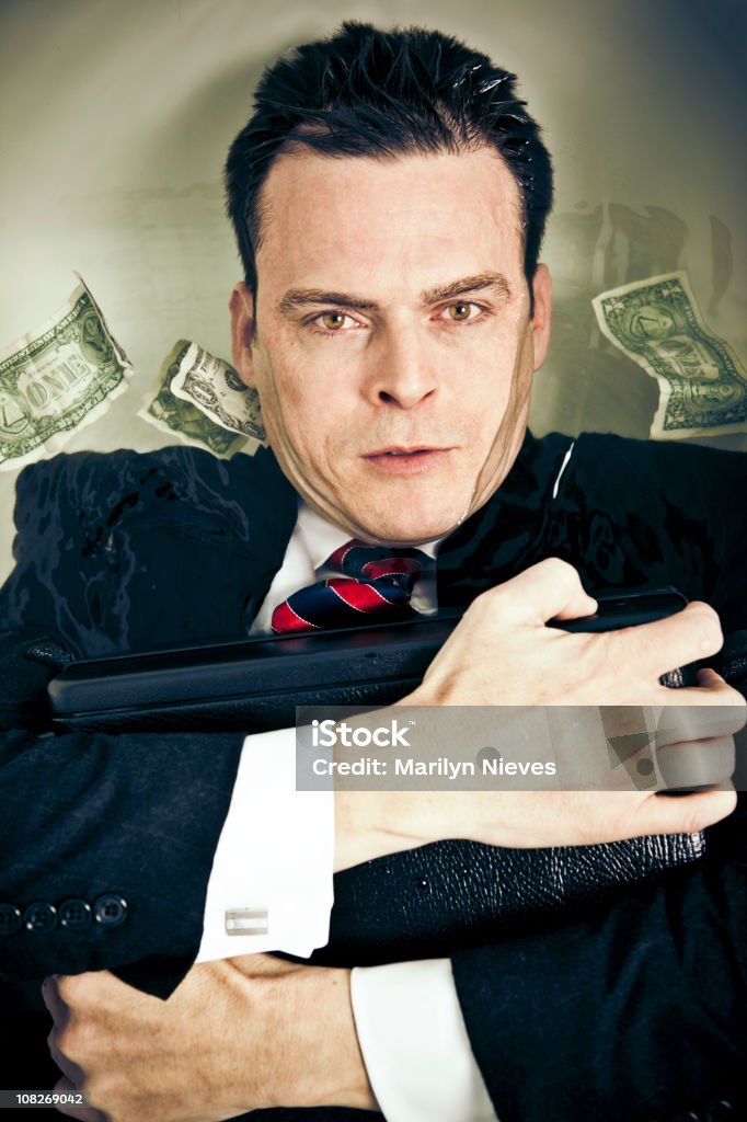 surviving the recession Businessman using his suitcase as a life preserver. Currency Stock Photo