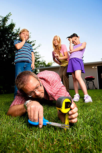 Meticulous Father Mowing the Lawn with Scissors  yard measurement stock pictures, royalty-free photos & images