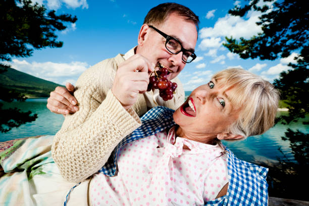 Senior's romance. feeding grapes stock pictures, royalty-free photos & images