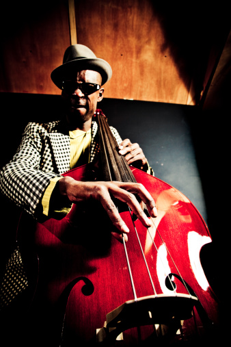 Double bass player playing contrabass. Classical musician. Focus is on the strings with bow