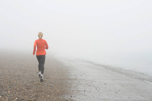 Runner on Foggy Beach stock photo