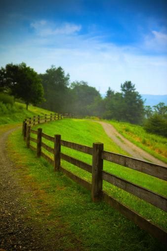 small country walking road and wooden fence the vicinity of Moses H. Cone Memorial Park. Blowing Rock - North Carolina, usa.