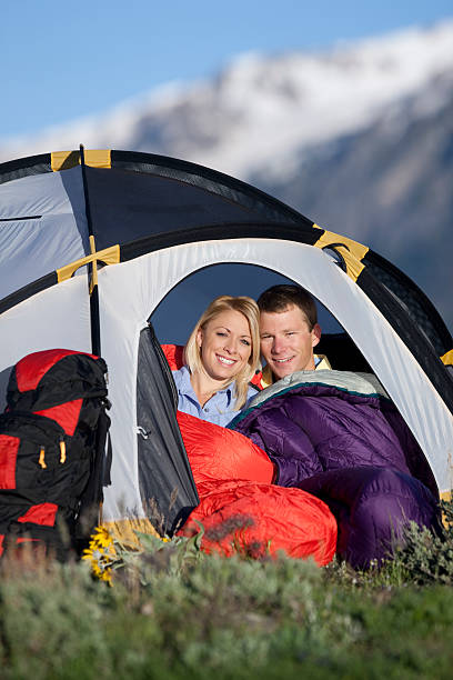 Young Couple Sitting Inside Small Tent In Mountains