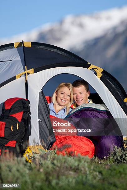 Young Couple Sitting Inside Small Tent In Mountains Stock Photo - Download Image Now