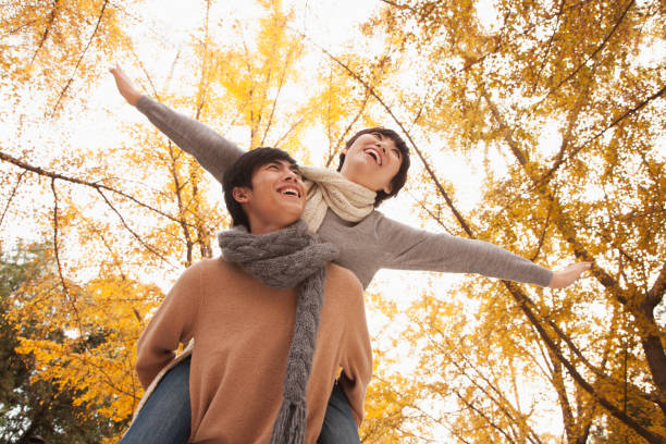 Chinese man giving girlfriend piggy back ride