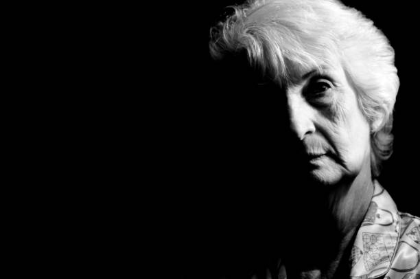 Portrait of an old woman photographed from the front. Clear image. Gray hair tied up.