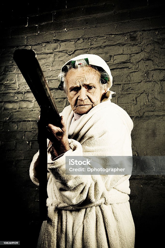 Sênior mulher usando rolo e segurando uma pistola - Foto de stock de Exterior royalty-free