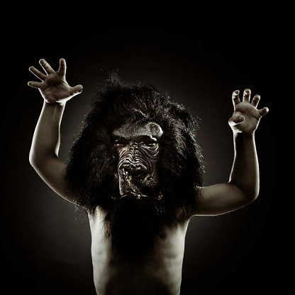 a young kid with a gorilla mask monkeying around on a menacing pose