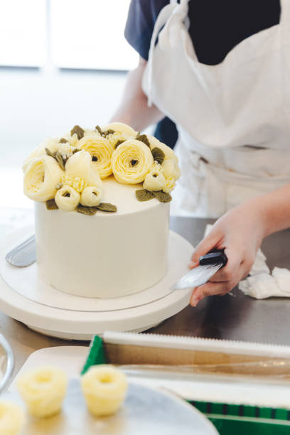 istock Pastry chef making a yellow butter flower for cake decoration. 1082702400