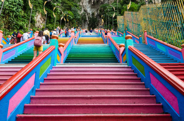 Scenic view of the Batu Caves in Gombak,Malaysia. People can seen climbing the stairs to or from the temple that is located inside the cave. stock photo