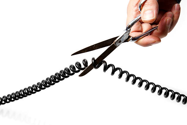 Hands Using Scissors to Cut Telephone Wire  alexander graham bell stock pictures, royalty-free photos & images