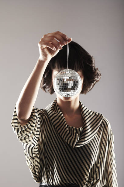 istock Attractive Young Woman Holding Up a Disco Ball 108270420