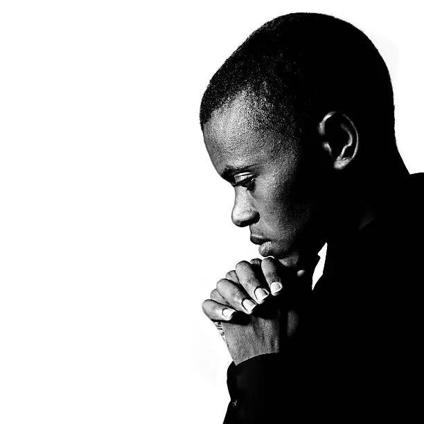 Photo of Black and white portrait of young man praying