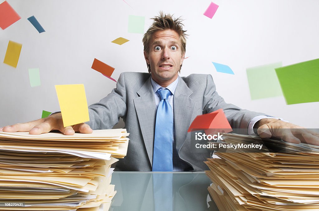 Stressed Businessman Office Worker Trying to Hold Down Chaos  Desk Stock Photo