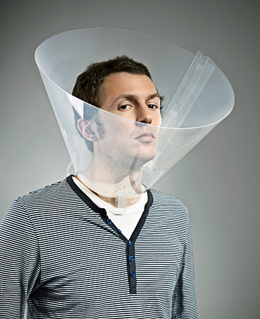 Portrait of young guy with dog cone on his head