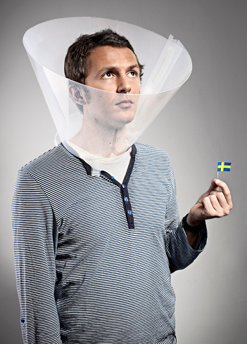 portrait of a man with swedish miniflag, indoors